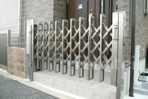 泉佐野市のバリカーポール車庫のセミクローズ外構　伸縮門扉　
