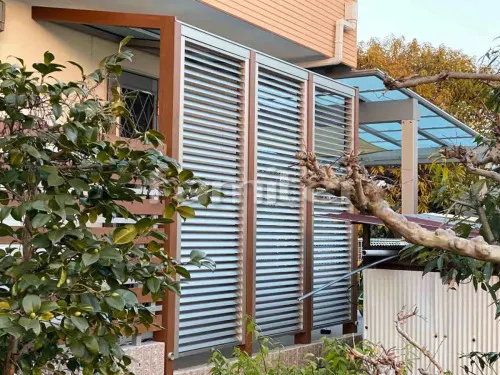 池田市 エクステリア工事 木製調テラス屋根 YKKAP アウタールーフ 1階用 F型フラット屋根 前面 正面パネル 多機能ルーバー 木製調目隠しフェンス塀 YKKAP ルシアスH03型 横板 細横格子 化粧ブロック ユニソン シャモティ